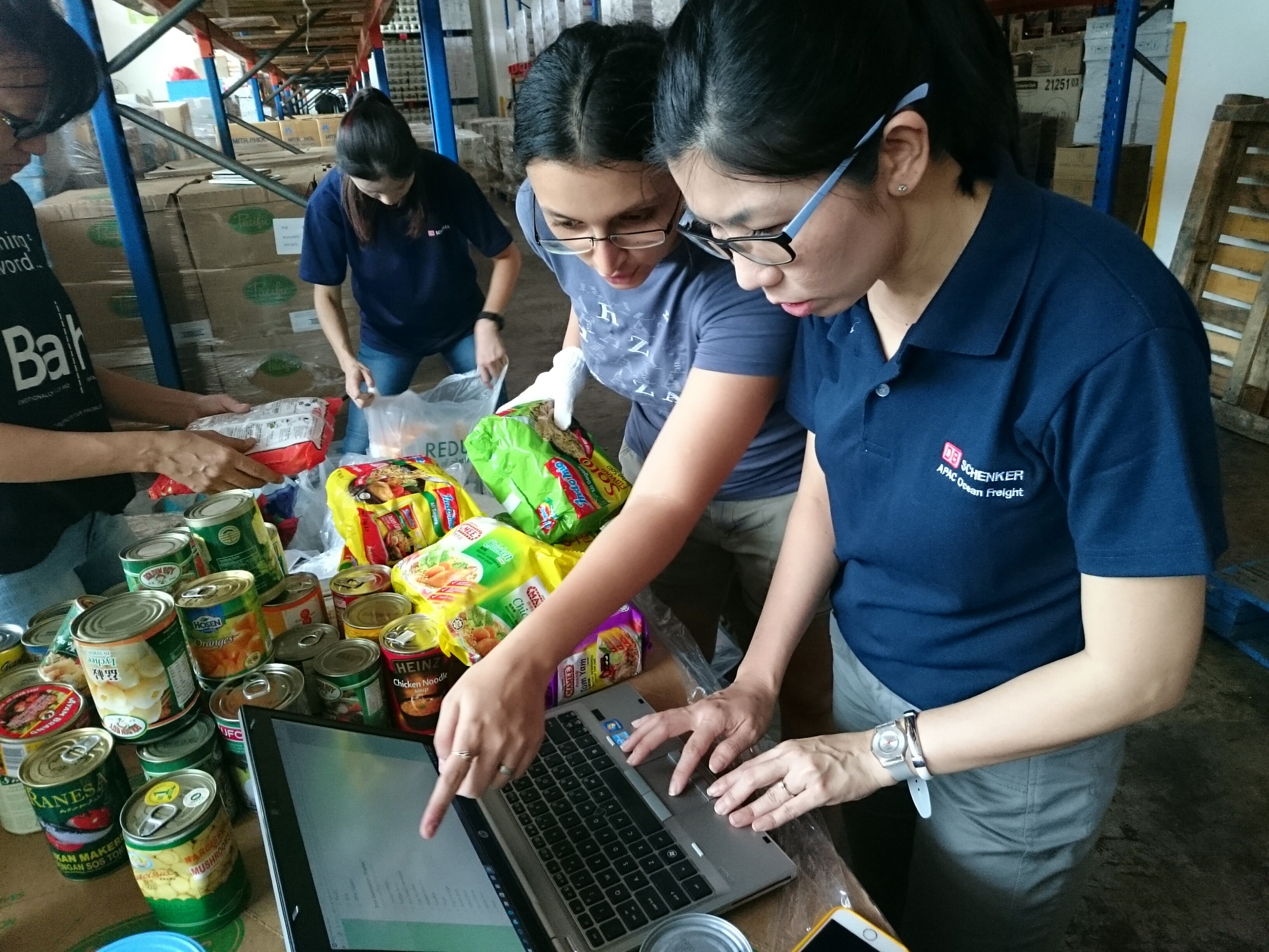 Volunteers recording information of donated food. (Courtesy of Food Bank Singapore)